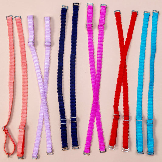 6 sets of interchangeable her-rah bra straps in a pleated organza patterns with a sheer shimmer to the fabric of various colors, from left to right: Just Peachy, Lavender, Navy Blue, Hot Pink, Cherry Tart and Blue Blast.