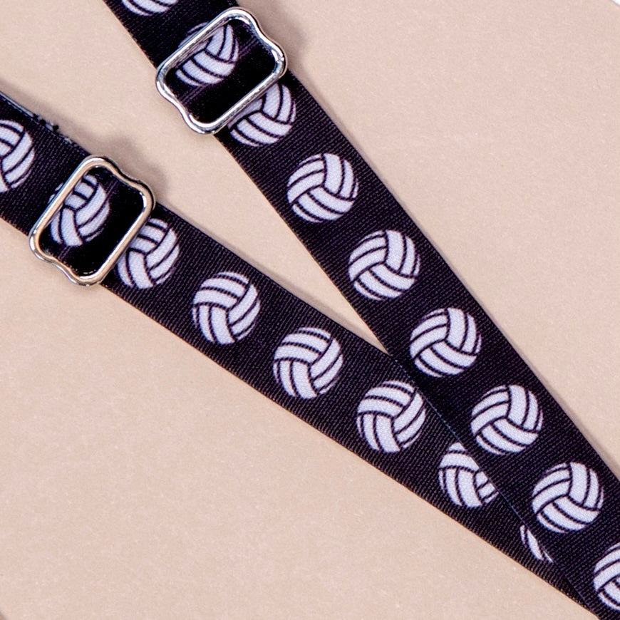 Black straps with white volleyballs repeating along length of material featuring Silver Metal hardware.