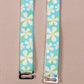 Dunk'n Daisies Her-Rah bra straps - Blue straps with white daisy like flowers with yellow center and green leaves, featuring silver hardware.