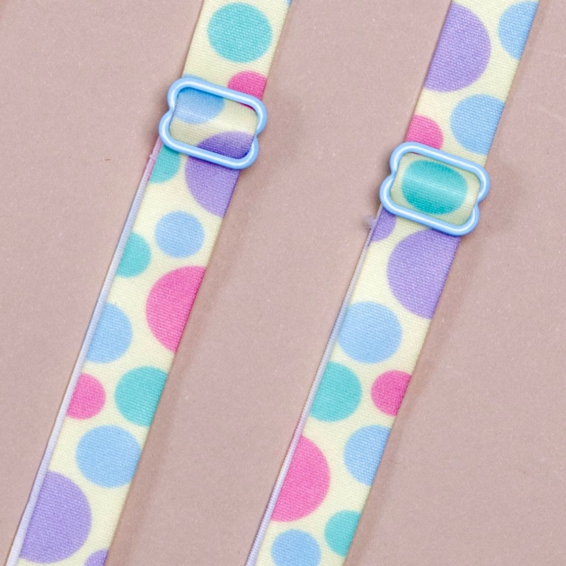Spring Fling Her-Rah Straps: White straps with a mix of various size polka dots in light blue, periwinkle, and hot pink, featuring blue coated hardware.