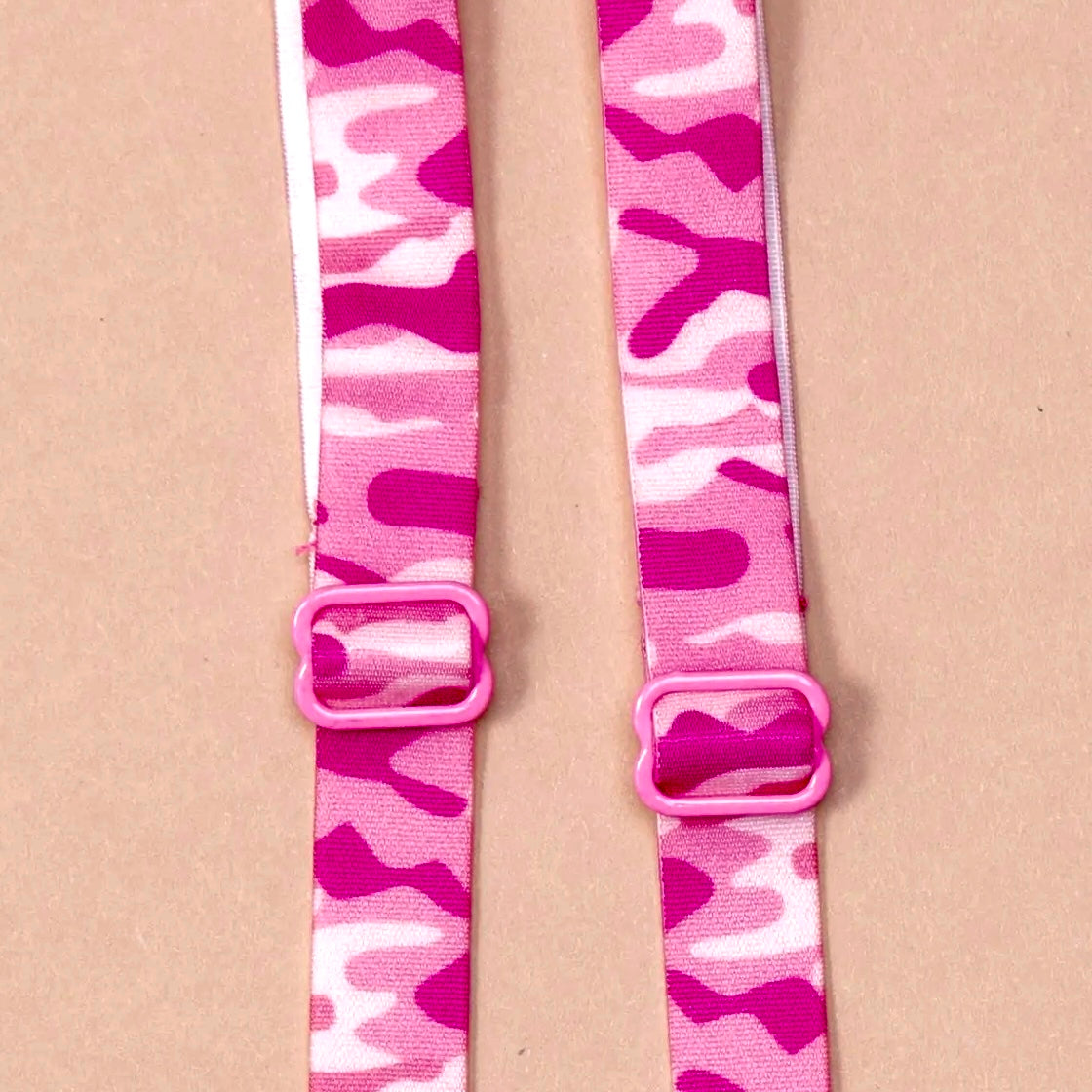 Close up of pink camo bra straps featuring pink coated metal hardware.